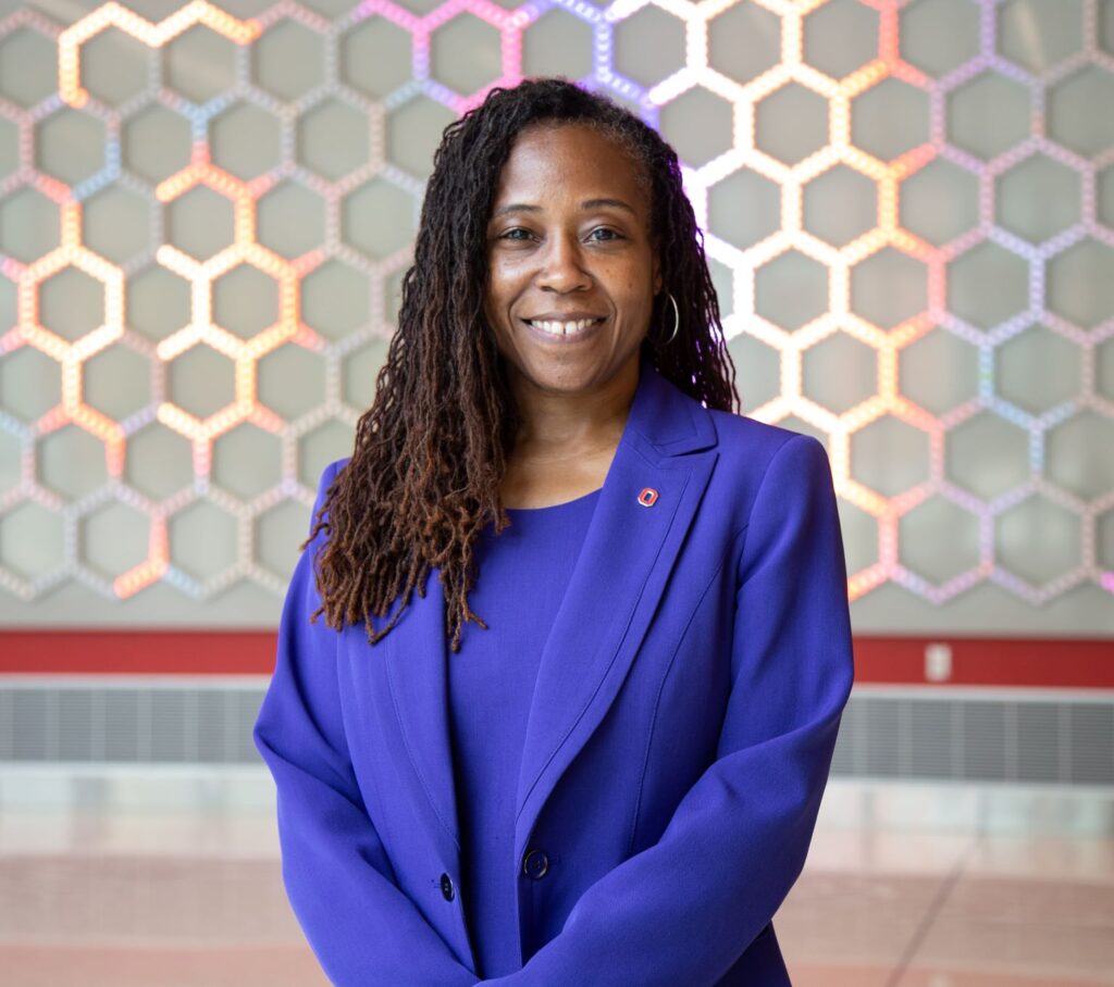 Photo of PEARC22 speaker Dean Ayanna Howard in purple suit with colorful background